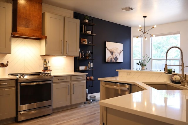 1654 Belvedere Pl, Round Rock, TX 78665 - kitchen with stainless steel appliances, light countertops, a chandelier, and light wood finished floors