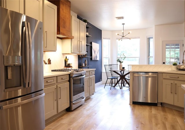 1654 Belvedere Pl, Round Rock, TX 78665 - kitchen featuring appliances with stainless steel finishes, light countertops, tasteful backsplash, light wood-type flooring, and a chandelier