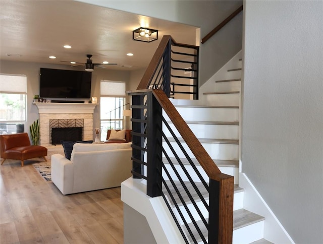 1654 Belvedere Pl, Round Rock, TX 78665 - staircase featuring wood finished floors, a fireplace, ceiling fan, and recessed lighting