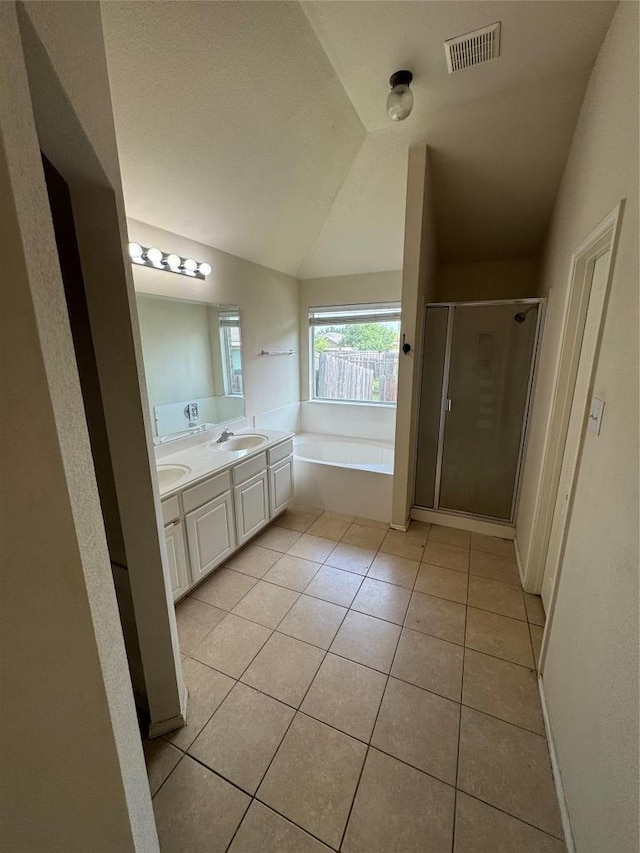 257 Firwood N, Kyle, TX 78640 - bathroom with tile patterned floors, a garden tub, a stall shower, double vanity, and vaulted ceiling