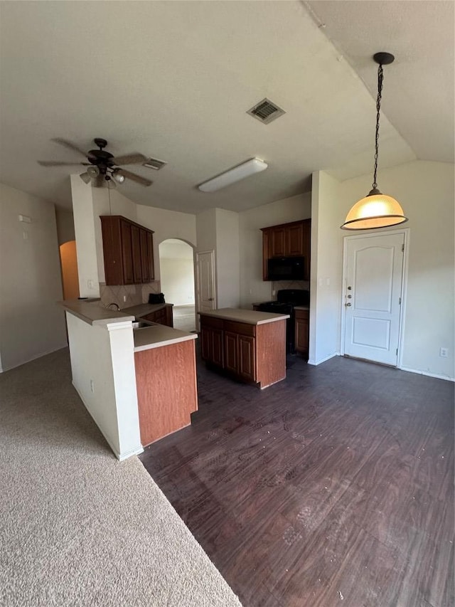 257 Firwood N, Kyle, TX 78640 - kitchen featuring black microwave, arched walkways, a peninsula, a ceiling fan, and dark wood finished floors