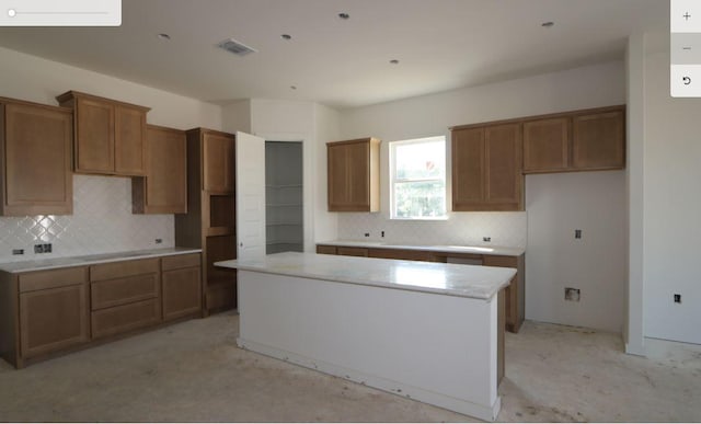 2008 Saco St, Leander, TX 78641 - kitchen featuring a kitchen island, tasteful backsplash, and brown cabinets