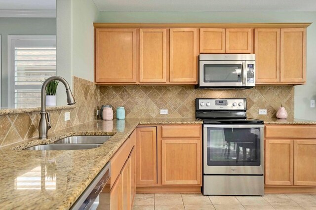 319 Salado Creek Ln, Georgetown, TX 78633 - kitchen with appliances with stainless steel finishes, light stone countertops, decorative backsplash, ornamental molding, and light tile patterned floors