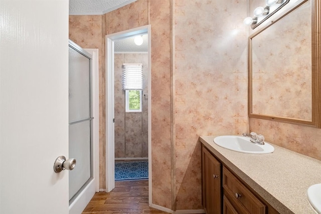 1231 Peach Creek Rd, Waelder, TX 78959 - full bath with a shower with shower door, double vanity, and wood finished floors