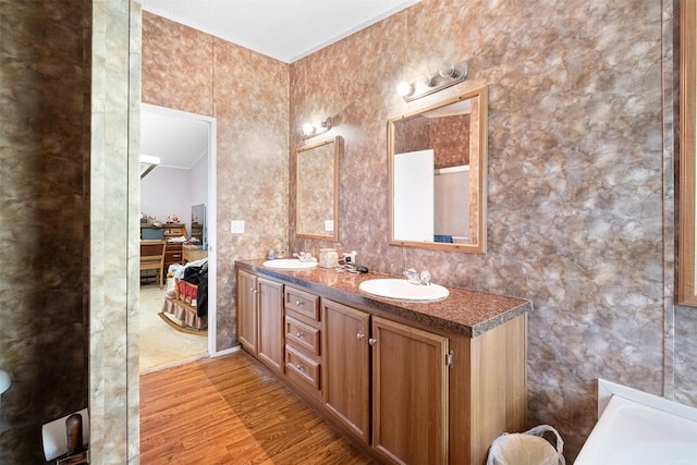 1231 Peach Creek Rd, Waelder, TX 78959 - full bath with wood finished floors, double vanity, and a tub