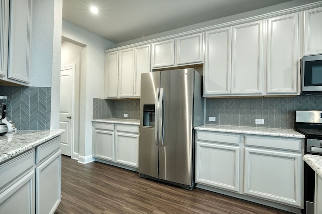 187 Glass Mountains Way, Dripping Springs, TX 78620 - kitchen with appliances with stainless steel finishes, backsplash, dark wood-type flooring, and light stone counters