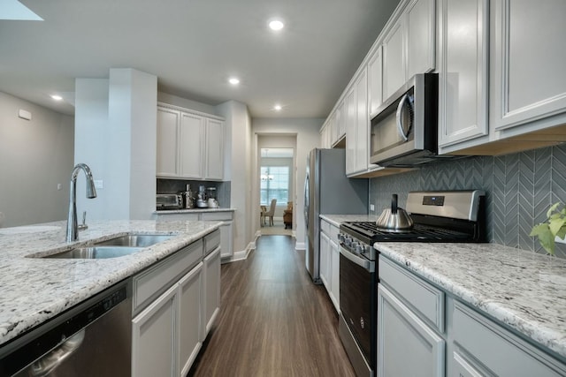187 Glass Mountains Way, Dripping Springs, TX 78620 - kitchen with stainless steel appliances, dark wood finished floors, tasteful backsplash, light stone countertops, and recessed lighting