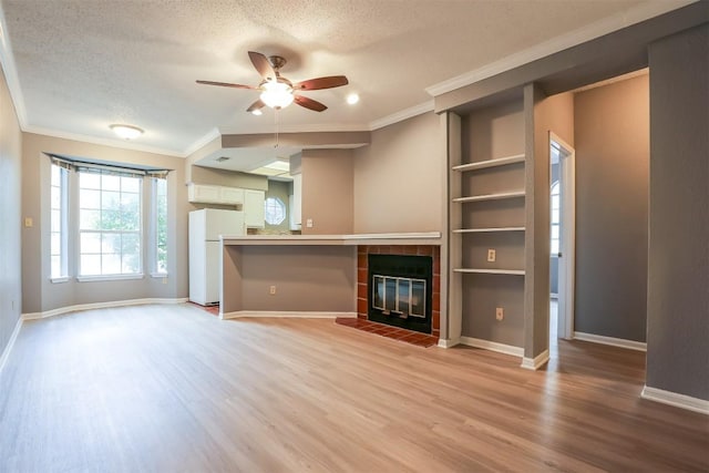 3111 Tom Green St Unit 105, Austin, TX 78705 - unfurnished living room with ceiling fan, light wood-type flooring, crown molding, a fireplace, and a textured ceiling