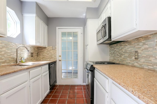 3111 Tom Green St Unit 105, Austin, TX 78705 - kitchen featuring appliances with stainless steel finishes, white cabinets, tasteful backsplash, and dark tile patterned floors