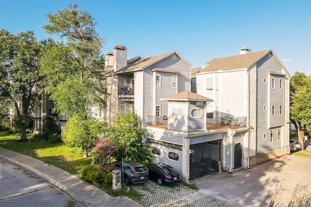 3111 Tom Green St Unit 105, Austin, TX 78705 - rear view of house featuring a garage, driveway, and a chimney