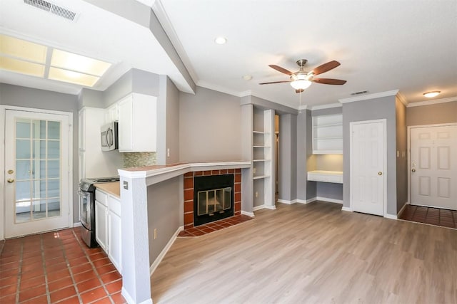 3111 Tom Green St Unit 105, Austin, TX 78705 - kitchen featuring stainless steel appliances, ceiling fan, white cabinets, light countertops, and ornamental molding