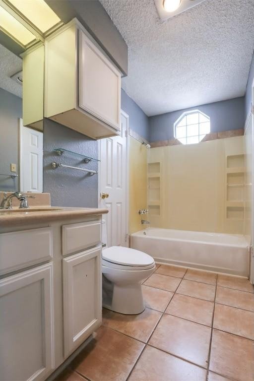 3111 Tom Green St Unit 105, Austin, TX 78705 - bathroom featuring a textured ceiling, vanity, tile patterned floors, and washtub / shower combination