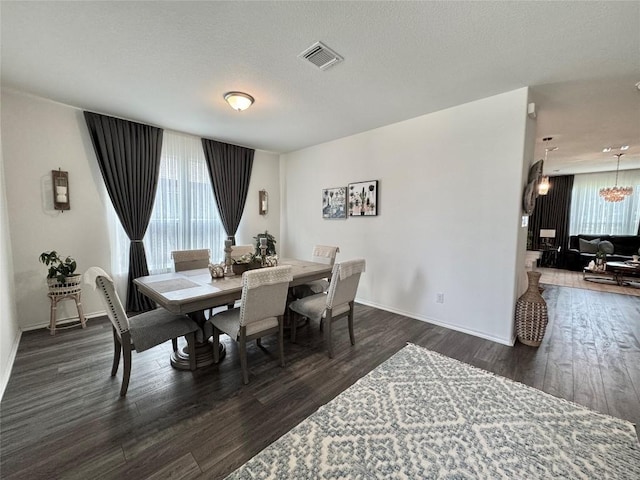 1121 Arbor Acres Loop, Leander, TX 78641 - dining area with dark wood finished floors, a chandelier, and a textured ceiling