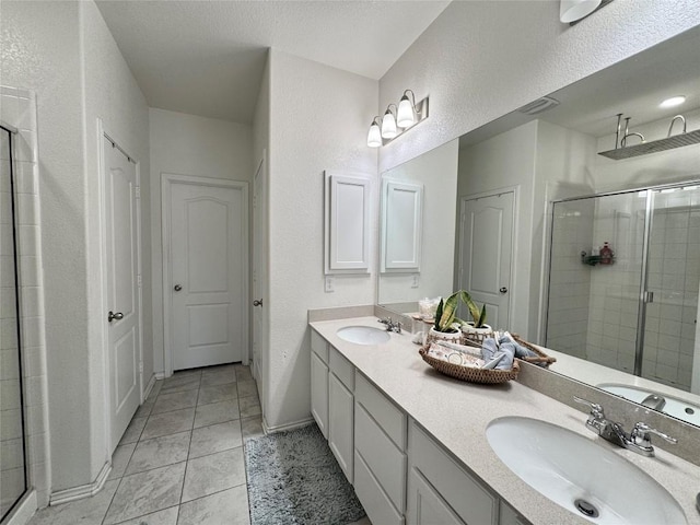 1121 Arbor Acres Loop, Leander, TX 78641 - bathroom with a shower stall, double vanity, tile patterned floors, and a textured wall