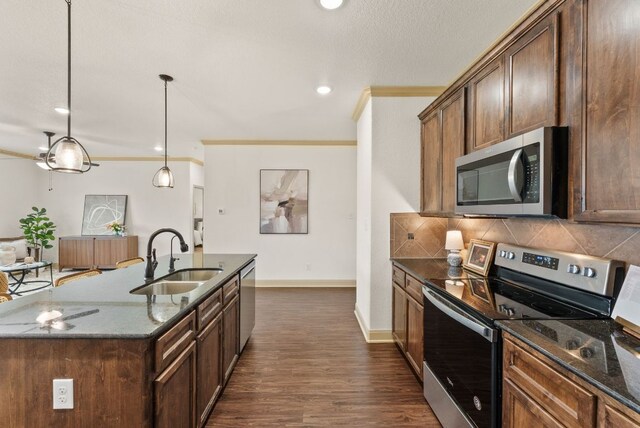 7606 Hickman St, Temple, TX 76502 - kitchen with appliances with stainless steel finishes, dark stone counters, decorative backsplash, dark wood-type flooring, and ornamental molding