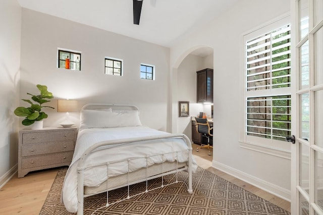 114 Reflection Bay Ct, Austin, TX 78738 - bedroom featuring light wood-type flooring, arched walkways, an office area, and a ceiling fan