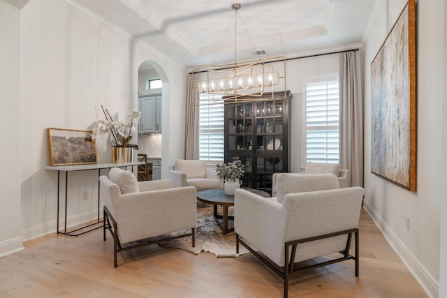114 Reflection Bay Ct, Austin, TX 78738 - living room featuring crown molding, arched walkways, light wood-style floors, a raised ceiling, and healthy amount of natural light