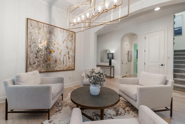 114 Reflection Bay Ct, Austin, TX 78738 - living room featuring arched walkways, wood finished floors, stairs, crown molding, and a chandelier