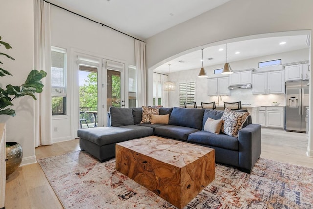 114 Reflection Bay Ct, Austin, TX 78738 - living room with light wood finished floors, arched walkways, and recessed lighting
