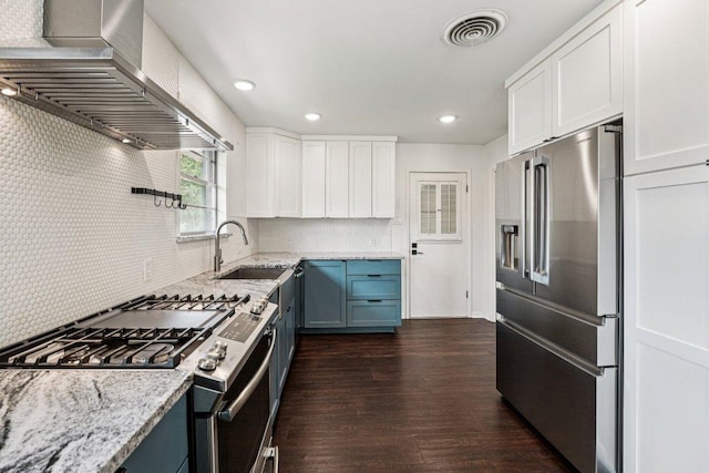 3806 Las Cienega Blvd, Temple, TX 76502 - kitchen with appliances with stainless steel finishes, wall chimney exhaust hood, light stone countertops, white cabinets, and dark wood-style flooring