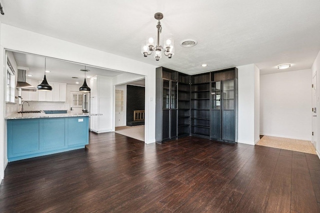 3806 Las Cienega Blvd, Temple, TX 76502 - kitchen with a chandelier, dark wood-style flooring, light stone counters, pendant lighting, and recessed lighting