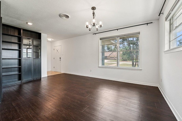 3806 Las Cienega Blvd, Temple, TX 76502 - unfurnished room with a chandelier, plenty of natural light, and dark wood-style flooring