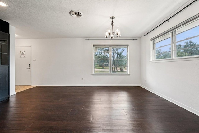 3806 Las Cienega Blvd, Temple, TX 76502 - unfurnished dining area featuring a chandelier, plenty of natural light, wood finished floors, and a textured ceiling