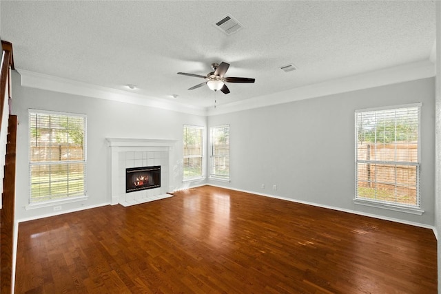 1217 Dove Cir, Cedar Park, TX 78613 - unfurnished living room featuring a ceiling fan, a textured ceiling, wood finished floors, a tile fireplace, and ornamental molding