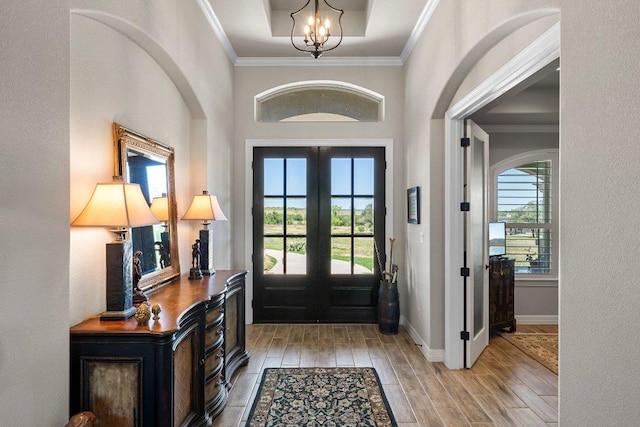 105 Clear Springs Ct, Marble Falls, TX 78654 - foyer entrance featuring light wood-style floors, a chandelier, ornamental molding, french doors, and arched walkways