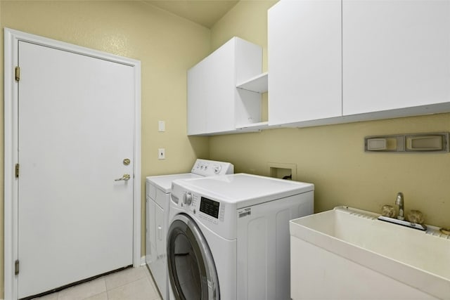 140 Whispering Wind Dr, Georgetown, TX 78633 - washroom featuring cabinet space, washing machine and clothes dryer, and light tile patterned flooring