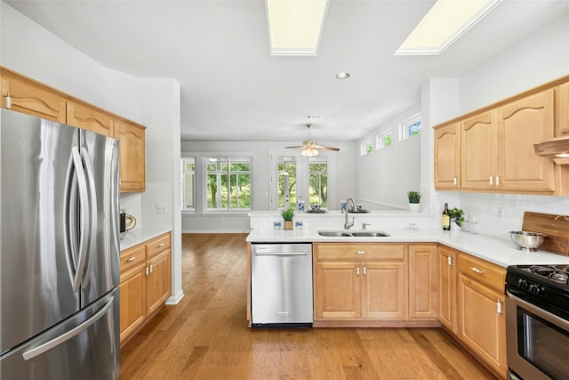 140 Whispering Wind Dr, Georgetown, TX 78633 - kitchen with appliances with stainless steel finishes, light wood-style floors, tasteful backsplash, light countertops, and recessed lighting