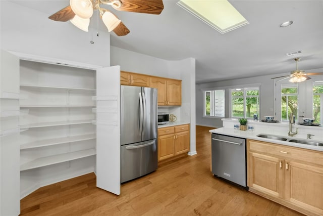 140 Whispering Wind Dr, Georgetown, TX 78633 - kitchen with appliances with stainless steel finishes, a ceiling fan, light brown cabinetry, light wood finished floors, and recessed lighting