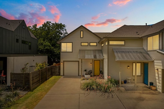 6204 Hickman Ave Unit A, Austin, TX 78723 - view of front facade with concrete driveway, an attached garage, a metal roof, and a standing seam roof