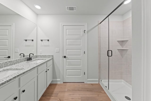 9509 Demure Dr Unit 5, Manor, TX 78653 - bathroom with double vanity, a stall shower, wood finished floors, and recessed lighting