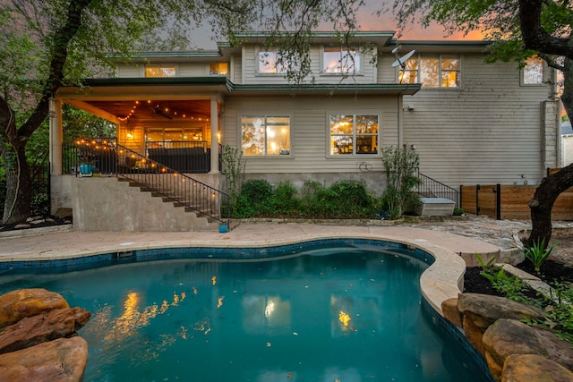 7709 Waldon Dr, Austin, TX 78750 - back of house at dusk with stairway and an outdoor pool