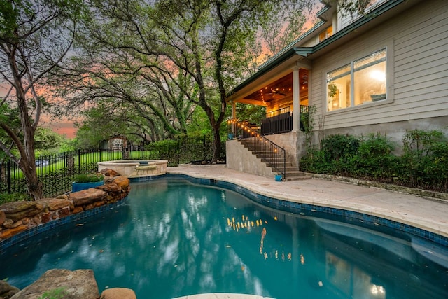 7709 Waldon Dr, Austin, TX 78750 - pool at dusk featuring stairway, a ceiling fan, a pool with connected hot tub, and a patio area