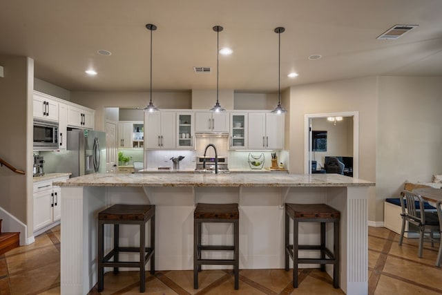 7709 Waldon Dr, Austin, TX 78750 - kitchen with appliances with stainless steel finishes, white cabinetry, tasteful backsplash, glass insert cabinets, and recessed lighting