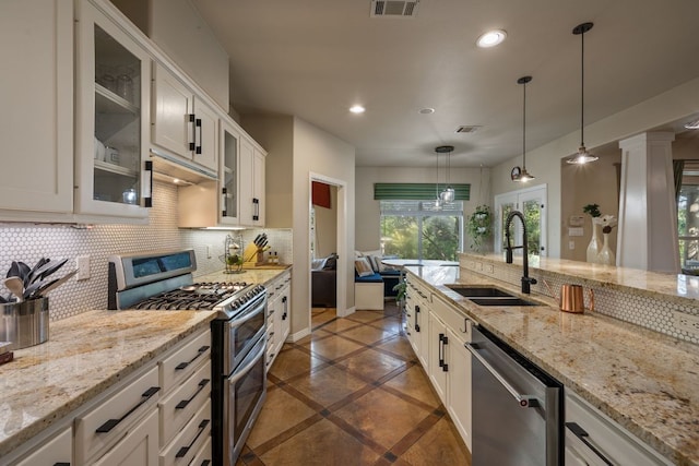 7709 Waldon Dr, Austin, TX 78750 - kitchen featuring stainless steel appliances, recessed lighting, backsplash, hanging light fixtures, and white cabinetry