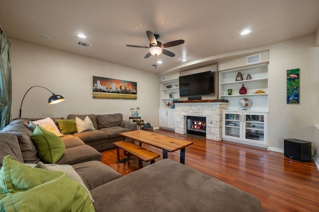 7709 Waldon Dr, Austin, TX 78750 - living area featuring a ceiling fan, wood finished floors, a stone fireplace, recessed lighting, and built in shelves