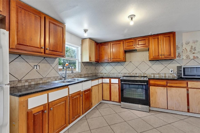 101 E Ash St, Granger, TX 76530 - kitchen with electric stove, stainless steel microwave, dark countertops, and tasteful backsplash