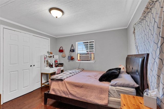 101 E Ash St, Granger, TX 76530 - bedroom with dark wood-type flooring, crown molding, cooling unit, a closet, and a textured ceiling