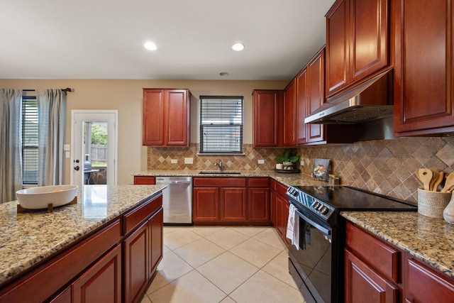 1012 Autumn Sage Way, Pflugerville, TX 78660 - kitchen with black electric range, stainless steel dishwasher, under cabinet range hood, reddish brown cabinets, and recessed lighting