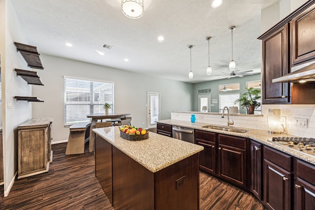 2502 Grey Kirby Dr, League City, TX 77573 - kitchen featuring appliances with stainless steel finishes, dark wood-style flooring, ceiling fan, a center island, and decorative backsplash