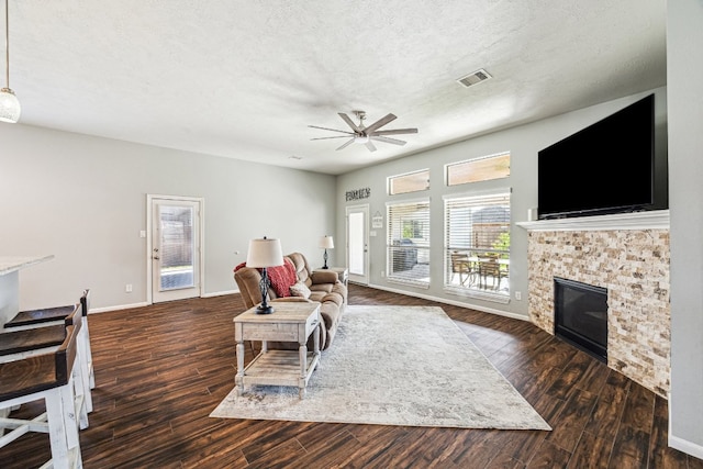 2502 Grey Kirby Dr, League City, TX 77573 - living room with ceiling fan, wood finished floors, a glass covered fireplace, and a textured ceiling