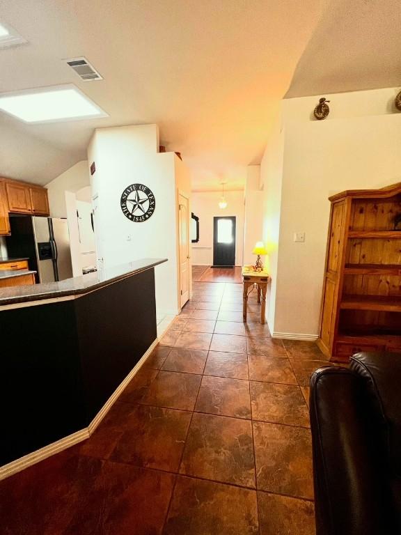 106 Hobbs Creek Cv, Cedar Creek, TX 78612 - corridor featuring lofted ceiling and dark tile patterned floors