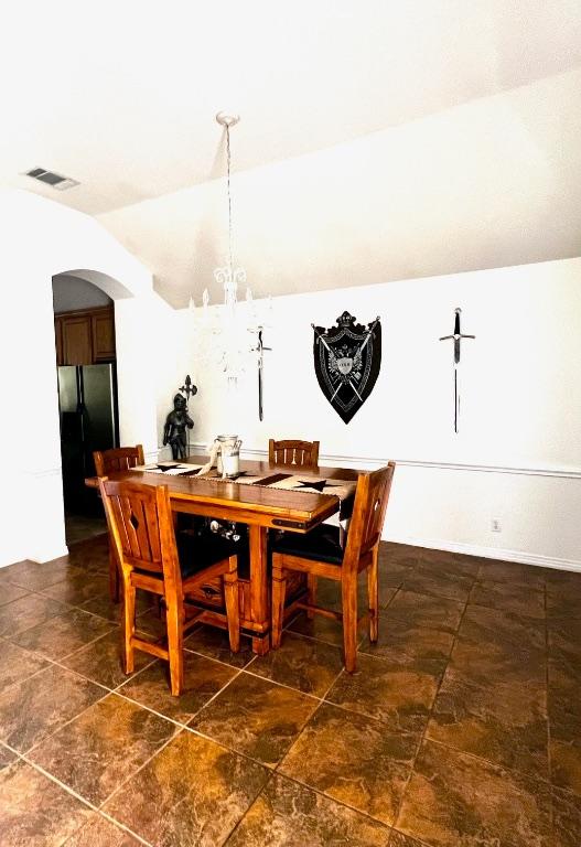 106 Hobbs Creek Cv, Cedar Creek, TX 78612 - dining area with arched walkways, lofted ceiling, and a chandelier
