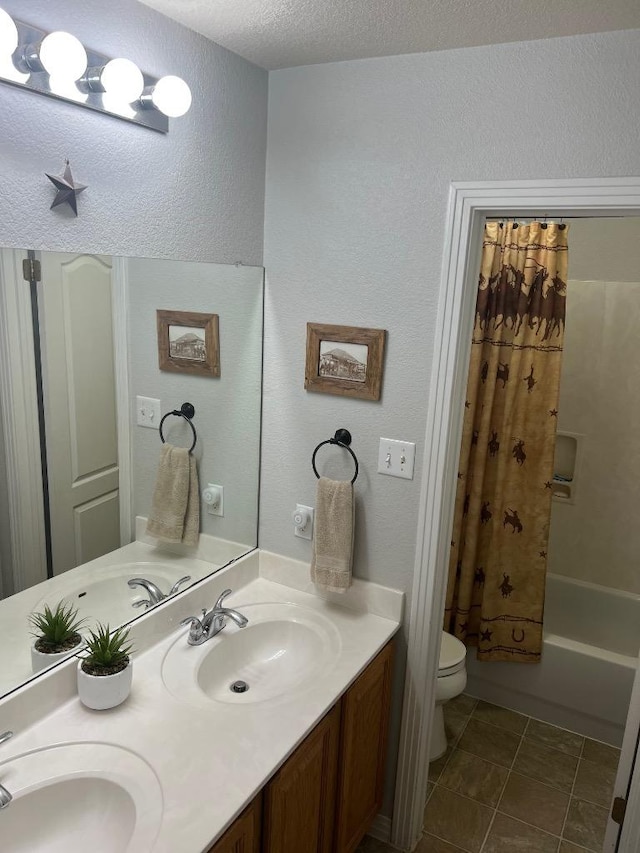 106 Hobbs Creek Cv, Cedar Creek, TX 78612 - bathroom with double vanity, a textured wall, shower / bath combo with shower curtain, and a textured ceiling