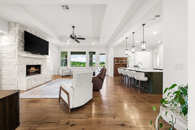 104 Huerta Rd, Florence, TX 76527 - living area featuring a fireplace, a ceiling fan, a tray ceiling, dark wood finished floors, and recessed lighting