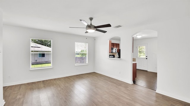 13124 Winecup Mallow Trl, Elgin, TX 78621 - unfurnished room with healthy amount of natural light, arched walkways, and ceiling fan