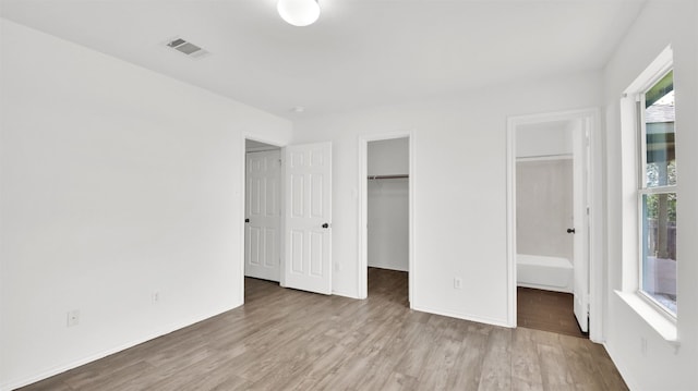 13124 Winecup Mallow Trl, Elgin, TX 78621 - unfurnished bedroom featuring wood finished floors, a walk in closet, and a closet